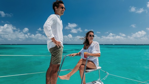 Romantic couple enjoying a catamaran trip on the ocean with clear blue waters