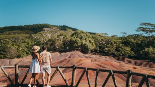 A couple admiring the panoramic view of the Seven Coloured Earth dunes in Chamarel, Mauritius